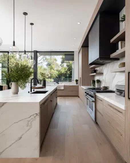 Kitchen Makeover Companies: Crafting California Luxury Kitchens Luxurious modern California kitchen with a marble waterfall island and warm wood cabinetry by a top kitchen makeover company.